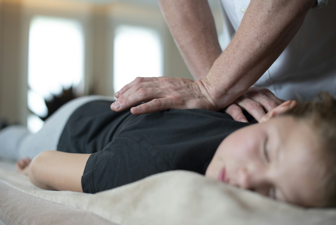 Massage services in Gilbert, AZ – therapist using long, flowing strokes across the shoulders