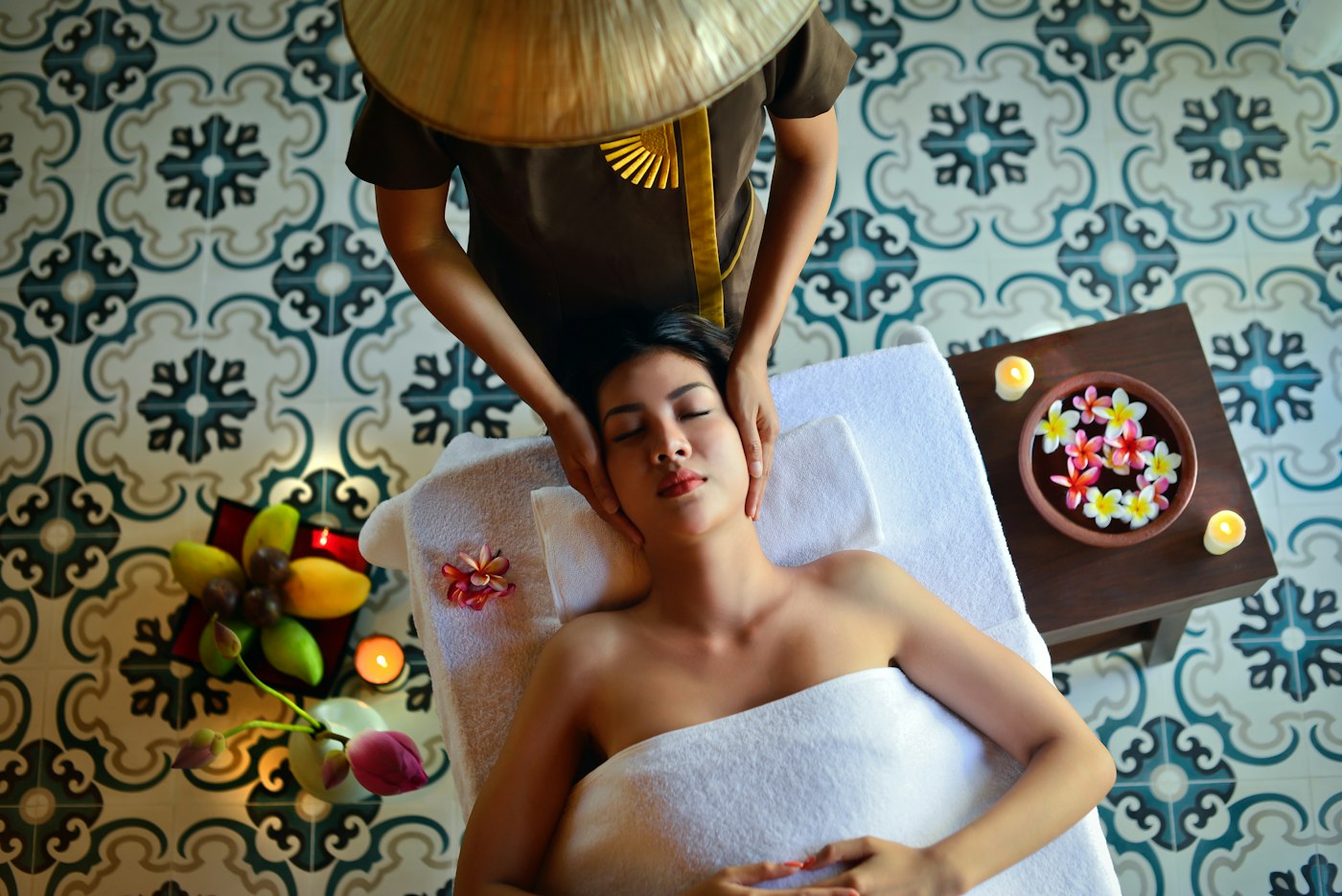 Massage prices in Gilbert, AZ – client resting on a massage table surrounded by tropical flowers