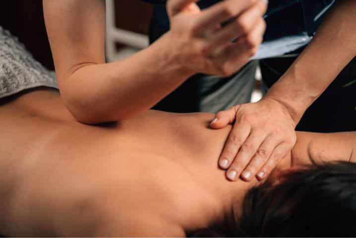 Asian massage stress relief in Mesa: therapist applying firm pressure to a man's upper back