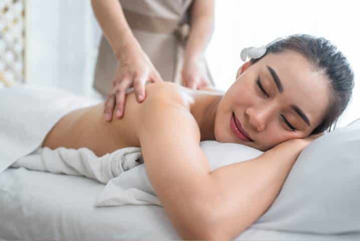 Asian massage stress relief in Mesa: smiling woman resting during a gentle back massage